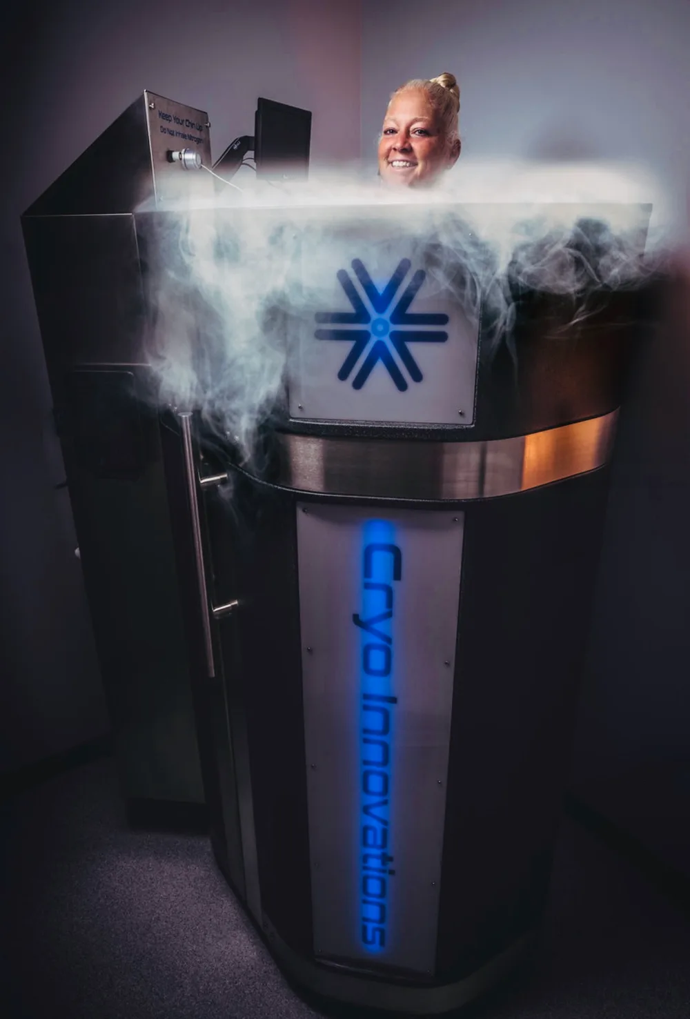 Smiling client mid-session in the XR chamber, nitrogen vapor rolling