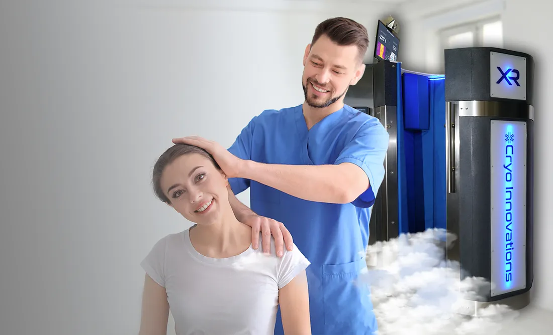 Chiropractor adjusting a smiling patient beside an XR cryotherapy chamber